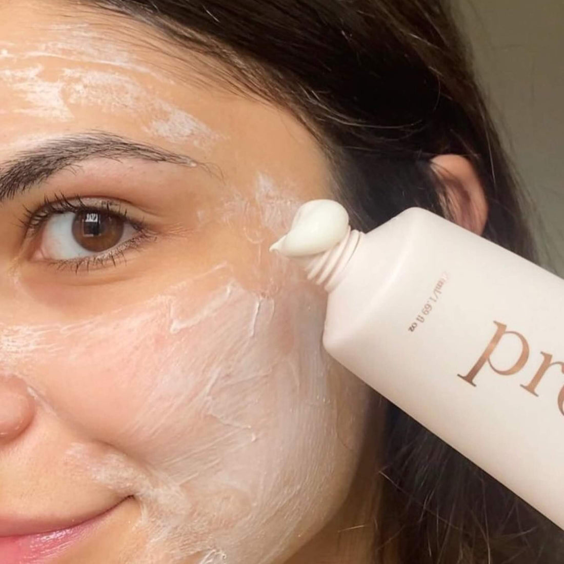 Woman applying creamy face mask for sensitive skin using Prota Skincare product, showcasing smooth texture and hydrating formula